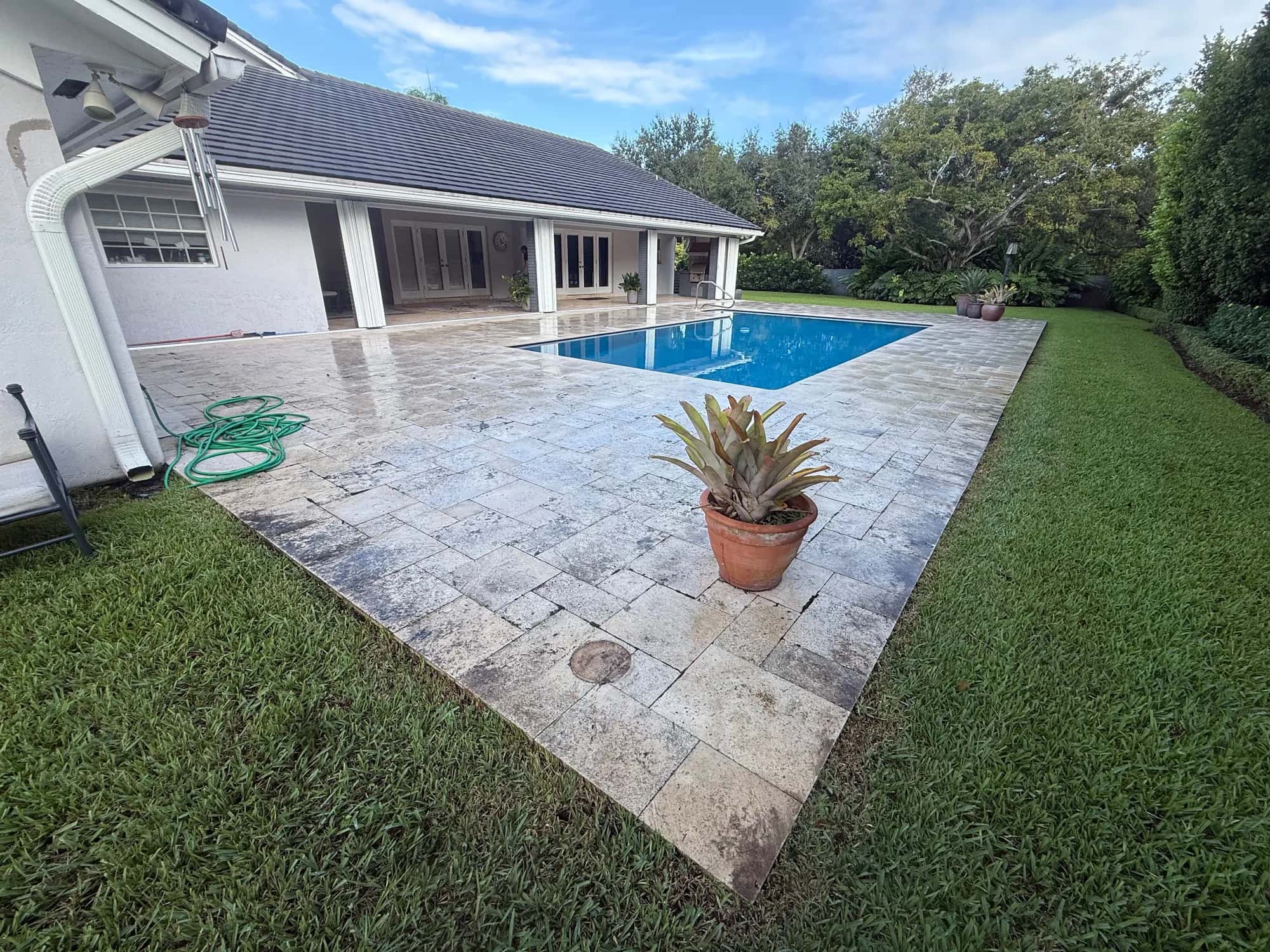 Gray, dirty pool deck pavers before pressure cleaning